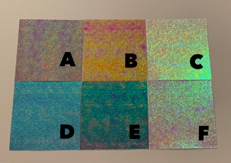 May include: Six iridescent samples of holographic vinyl, labeled A through F. The samples are arranged in two rows of three, with each sample showing a different color shift.