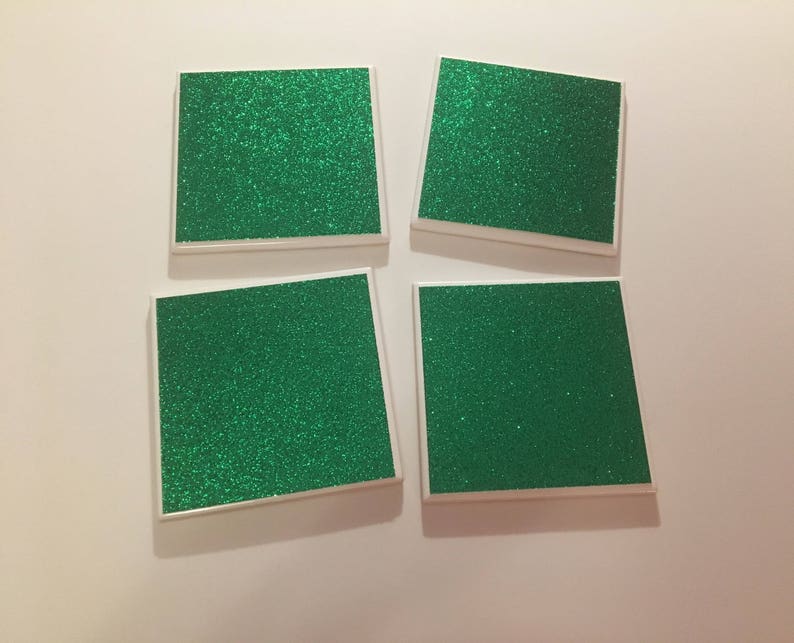 May include: Four square green glitter coasters with white borders.