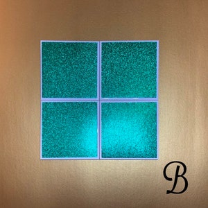 Peut inclure: Ensemble de quatre sous-verres en paillettes vert turquoise avec une bordure blanche. Les sous-verres sont dispos&eacute;s en grille 2x2.