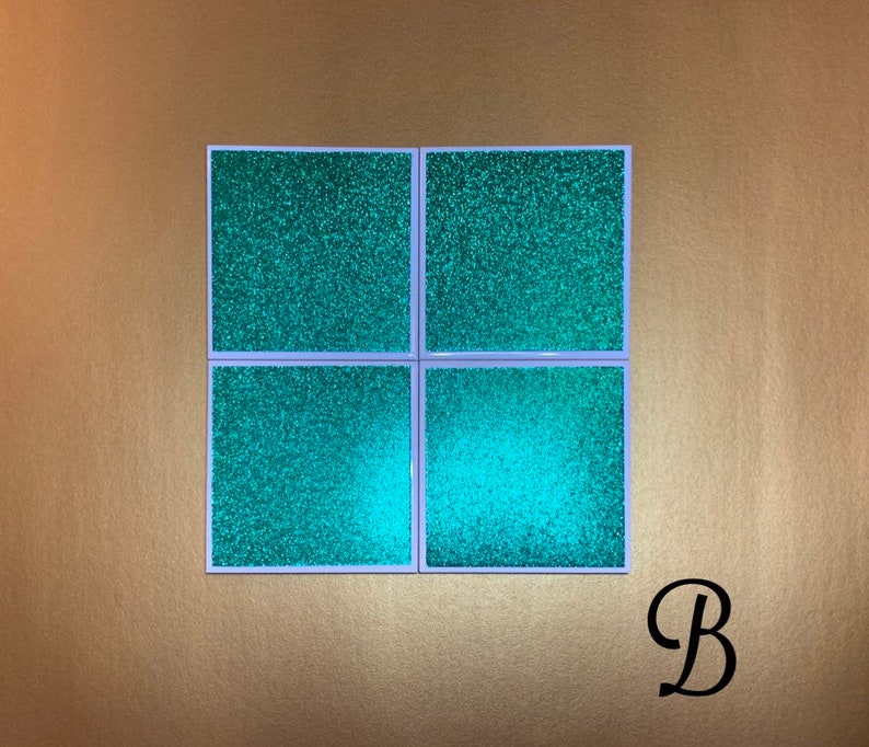Peut inclure: Ensemble de quatre sous-verres en paillettes vert turquoise avec une bordure blanche. Les sous-verres sont dispos&eacute;s en grille 2x2.