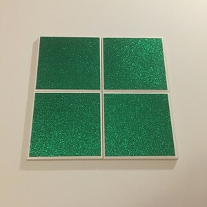 May include: Four square green glitter tiles with white borders.