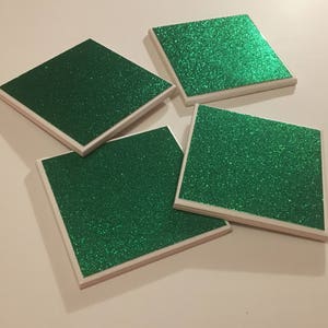May include: Four square green glitter coasters with white edges.