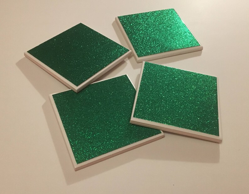 May include: Four square green glitter coasters with white edges.