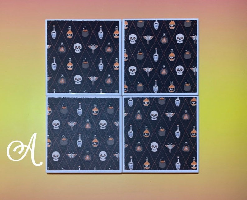 Puede incluir: Cuatro posavasos cuadrados con un patr&oacute;n tem&aacute;tico de Halloween. El dise&ntilde;o presenta calaveras, botellas de pociones y polillas sobre un fondo negro con una cuadr&iacute;cula de diamantes. Cada posavasos tiene un borde blanco.