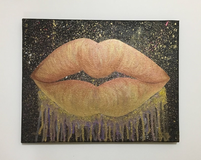 Pu&ograve; includere: Un primo piano di un dipinto che raffigura un paio di labbra con uno schema di colori oro e arancio. Le labbra sono su uno sfondo nero con macchie dorate e bianche. La parte inferiore delle labbra ha un effetto gocciolante con vernice dorata e viola.