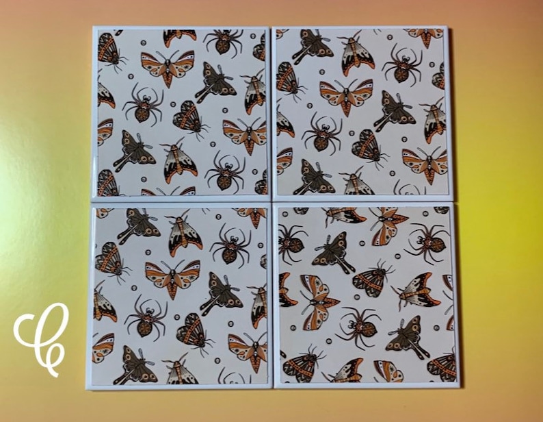 Puede incluir: Cuatro posavasos cuadrados con un patr&oacute;n repetido de polillas y ara&ntilde;as sobre un fondo crema. Los insectos son en tonos marrones y negros. Cada posavasos tiene un borde blanco.