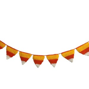 May include: A crocheted banner featuring triangular pennants in a candy corn color scheme: yellow, orange, and white. The banner is strung on a thin orange cord, perfect for festive decorations.