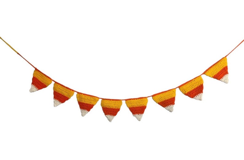May include: A crocheted banner featuring triangular pennants in a candy corn color scheme: yellow, orange, and white. The banner is strung on a thin orange cord, perfect for festive decorations.