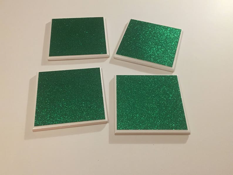 May include: Four square green glitter coasters with white borders.