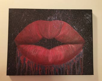 May include: A close-up of a red painted lip print on a black canvas background with a splatter effect. The lip print is dripping with red and blue paint.
