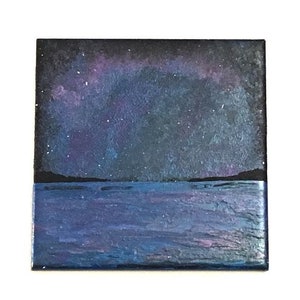 Puede incluir: Una pintura de un cielo nocturno estrellado sobre un cuerpo de agua azul oscuro. El cielo es de un azul profundo con un efecto de aurora boreal p&uacute;rpura y rosa. El agua es de un azul oscuro con un ligero efecto de ondulaci&oacute;n.
