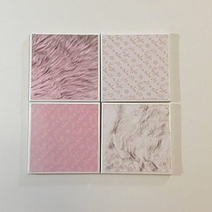 May include: Four square tiles with different patterns. The top left tile has a pink fuzzy texture. The top right tile has a white background with a light pink repeating pattern. The bottom left tile has a solid pink colour with a light pink repeating pattern. The bottom right tile has a white fuzzy texture.