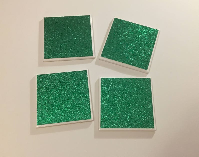 May include: Four square green glitter coasters with white borders.