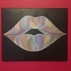 May include: A rectangular canvas painting featuring a pair of lips centered on a solid black background. The lips are rendered with blended brushstrokes of iridescent pastel colors including pink, purple, yellow, and blue, with a dark gap in the center.