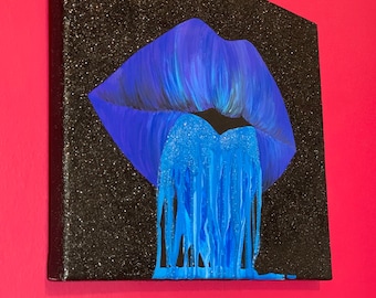 May include: A blue glitter lip print on a black glitter canvas. The lip print is dripping with blue glitter.