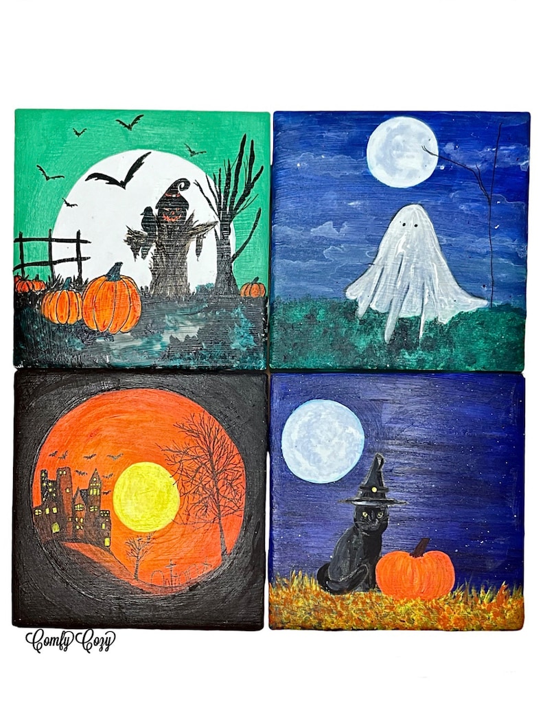 Op de afbeelding: Vier vierkante schilderijen met Halloween-thema. E&eacute;n toont een vogelverschrikker, pompoenen en een volle maan. Een andere toont een spook onder een volle maan. Een derde toont een spookhuis met een volle maan. De laatste toont een zwarte kat met een heksenhoed en een pompoen.
