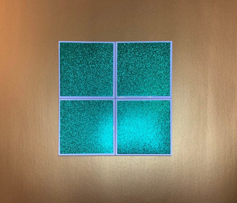 Peut inclure: Quatre sous-verres carr&eacute;s en paillettes turquoise avec des bordures blanches.