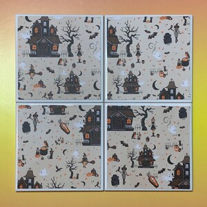 Pu&ograve; includere: Un set di quattro sottobicchieri quadrati in ceramica con un motivo ripetuto su sfondo beige. Il design include case infestate nere, zucche arancioni, fantasmi bianchi, gatti neri, pipistrelli, lune crescenti e streghe su manici di scopa.