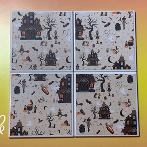 Pu&ograve; includere: Un set di quattro sottobicchieri quadrati in ceramica con un motivo ripetuto di Halloween su sfondo beige. Il design include case infestate nere, zucche arancioni, fantasmi bianchi, streghe volanti su manici di scopa, pipistrelli e bare.
