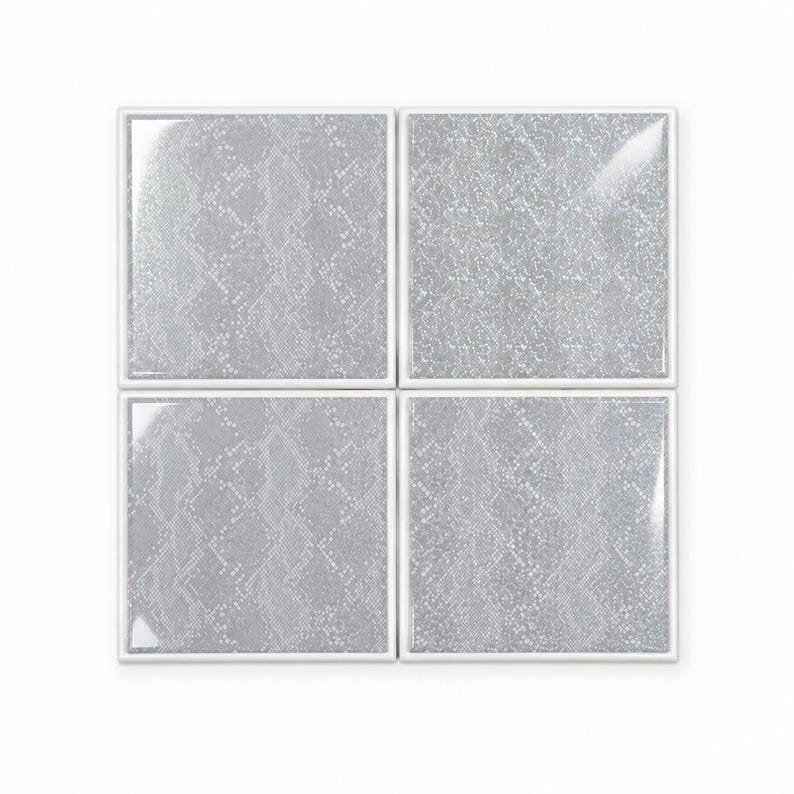 Peut inclure: Un ensemble de quatre carreaux de c&eacute;ramique carr&eacute;s dispos&eacute;s en une grille de deux par deux. Chaque carreau pr&eacute;sente une finition brillante avec un motif peau de serpent gris clair et blanc. Les carreaux ont une bordure blanche nette.