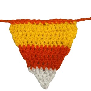 May include: A handmade crochet candy corn banner. The banner features a triangle shape with orange, yellow, and white sections, resembling candy corn. The banner is made of yarn and is suitable for Halloween or fall decor.
