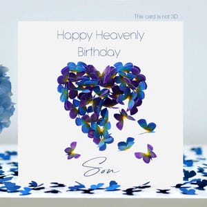 Könnte beinhalten: Eine weiße Grußkarte mit dem Text "Happy Heavenly Birthday Son". Die Karte zeigt ein herzförmiges Design aus blauen und violetten Schmetterlingsillustrationen. Blauer Blumenstrauß in einer Glasvase.