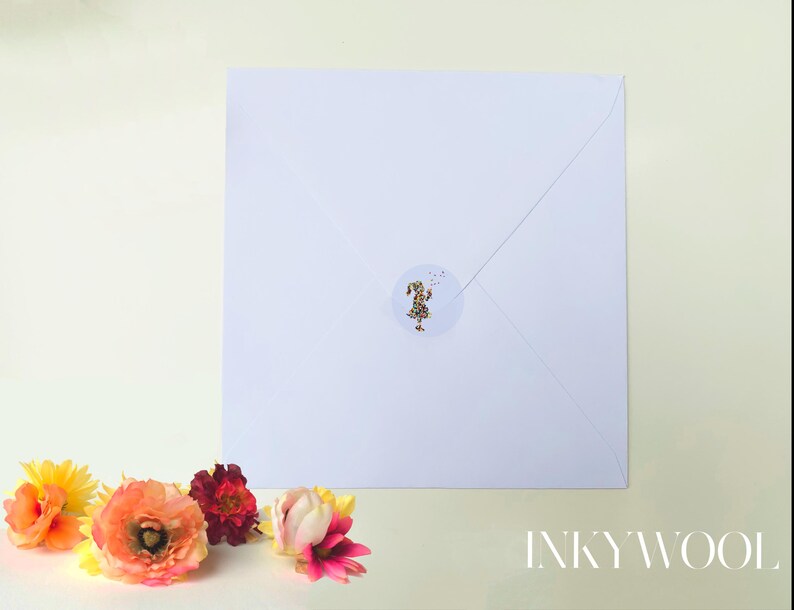 May include: A white square envelope sealed with a round sticker featuring gold flecks. The envelope is surrounded by colorful flowers in shades of orange, red, and pink. The text "INKYWOOL" is visible in the bottom right corner.