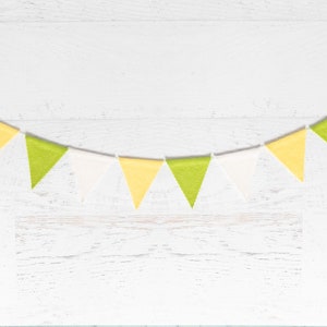 May include: A string of yellow, green, and white triangular flags hanging against a white wood background.