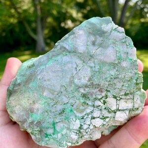 May include: A large, rough, green and white, natural stone with a unique, marbled pattern.