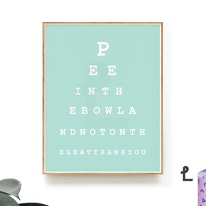 May include: A light blue framed print with a white eye chart that reads "P EE INTH EBOWLA NDNOT&Omicron;&Nu;&Tau;&Eta; ESEATTHANKYOU".
