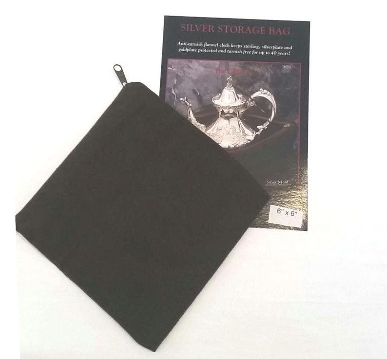 May include: A black felt storage bag with a zipper closure. The bag is designed to protect silver items from tarnishing. The bag is 6 inches by 6 inches.