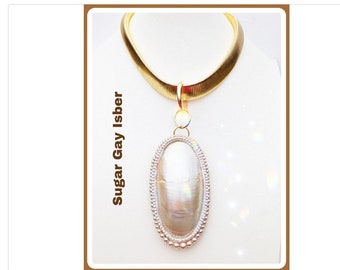 May include: A gold chain necklace with a large oval pendant featuring a white iridescent shell. The pendant is surrounded by a border of small white pearls.