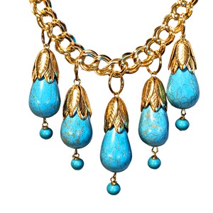 May include: A gold chain necklace with five turquoise teardrop pendants. Each pendant has a gold cap with a leaf design.