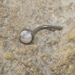 Könnte beinhalten: Ein Nasenring aus weißem Howlith mit einem silbernen Stein und einem gebogenen Stift.