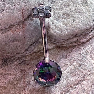 May include: A black body piercing with a small flower-shaped top and a large, round, iridescent gemstone.