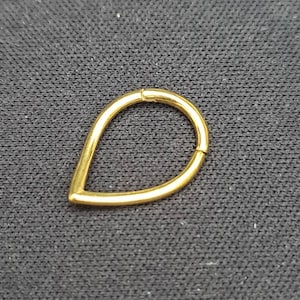 May include: A gold teardrop-shaped hoop earring. The hoop is open and has a smooth finish.