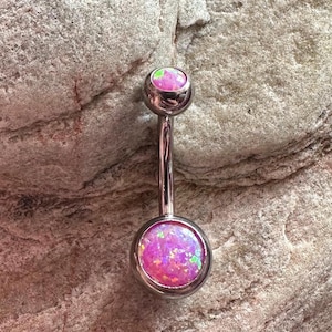May include: A silver belly button ring with two pink opal stones. The stones have a sparkly, iridescent finish.