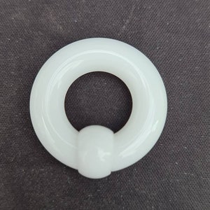 May include: White circular ring with a ball on one side. The ring is made of a smooth, glossy material.