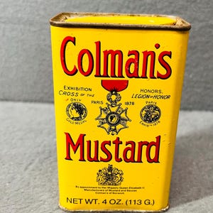 May include: Yellow metal tin with red and black lettering that reads "Colman's Mustard". The tin has a red and gold emblem with the text "Exhibition Cross of the Paris 1878" and "Honors Legion of Honor Paris Exhibit 1878". The tin also has a royal crest and the text "By appointment to Her Majesty Queen Elizabeth II Manufacturers of Mustard and Sauces Colman's of Norwich" and "Net Wt. 4 oz. (113 g.)".
