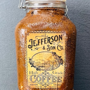 May include: A brown glass jar with a metal lid and a vintage label that reads "Jefferson & Son Co. High Grade Coffee" with the words "Boston One Pound" and "Chicago Net Weight" at the bottom.