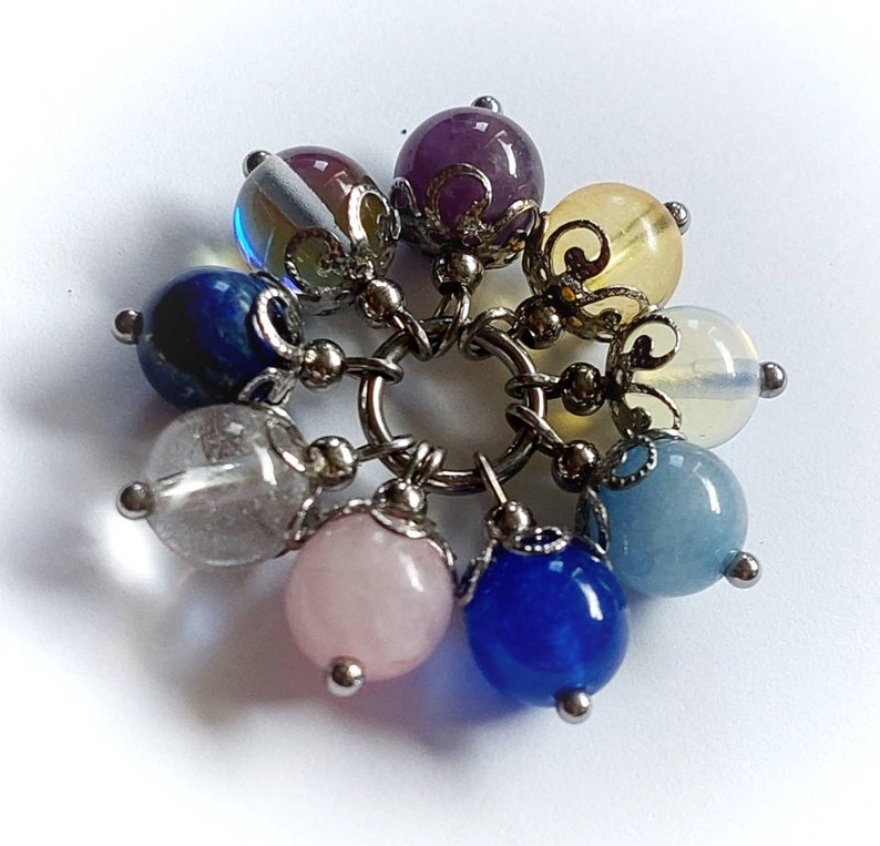 Puede incluir: Un brazalete con charms con una variedad de cuentas de piedras preciosas, incluyendo amatista, cuarzo transparente, aguamarina, cuarzo rosa, lapisl&aacute;zuli y citrino. Las cuentas est&aacute;n conectadas por una cadena de plata.
