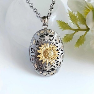 May include: A silver locket necklace with a delicate filigree design and a gold sunflower charm.