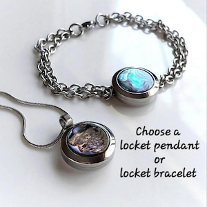 May include: A silver-toned metal locket bracelet with a round abalone shell inlay and a matching locket pendant on a thin snake chain. The text reads: Choose a locket pendant or locket bracelet. The jewelry features iridescent blue and green tones.