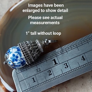 Puede incluir: Un charm de plata con una cuenta de porcelana azul y blanca y una parte superior decorativa. El charm mide 2,5 cm de alto sin el bucle. Las im&aacute;genes se han ampliado para mostrar los detalles. Consulte las medidas reales.