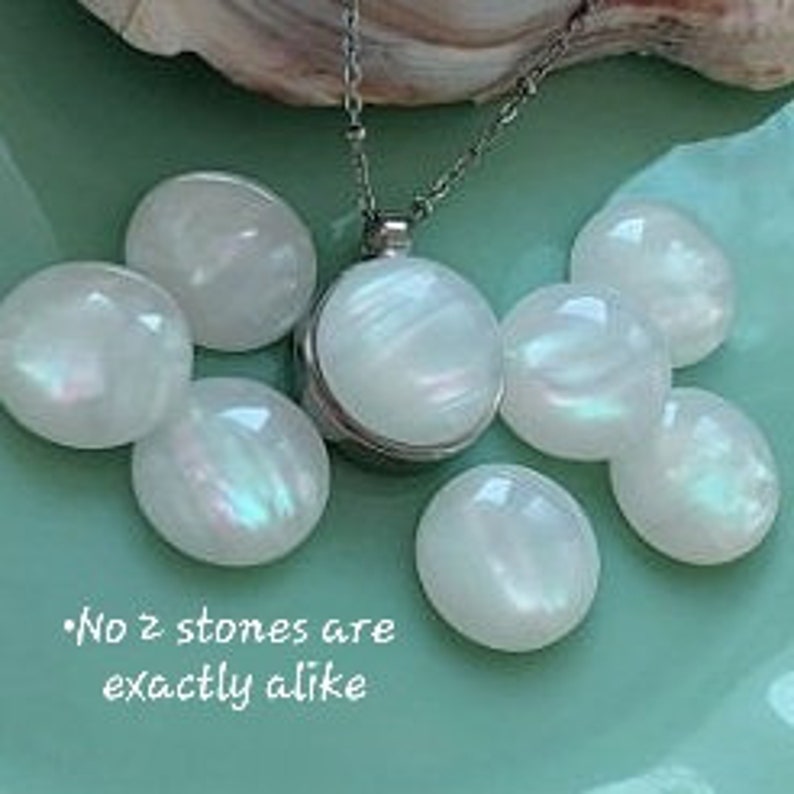 Peut inclure: Un collier pendentif argent&eacute; avec une pierre blanche ronde et iris&eacute;e. Plusieurs pierres ovales blanches et iris&eacute;es entourent le collier. Le texte sur l'image indique : "No 2 stones are exactly alike."