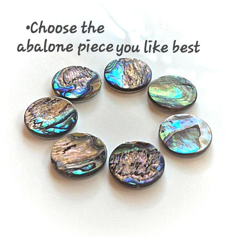 May include: Six circular abalone shell pieces arranged in a circle, each featuring iridescent blue, green, and brown patterns. The text "Choose the abalone piece you like best" is printed in dark gray above the shell pieces on a white background.
