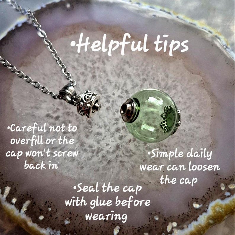 May include: A silver-toned necklace with a decorative pendant and a clear, green glass orb. The orb has a silver-toned cap and a decorative design. Text on the image reads "Helpful tips" and provides care instructions.