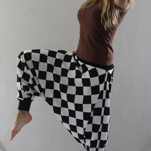May include: A person wearing black and white checkered pants with a brown top.