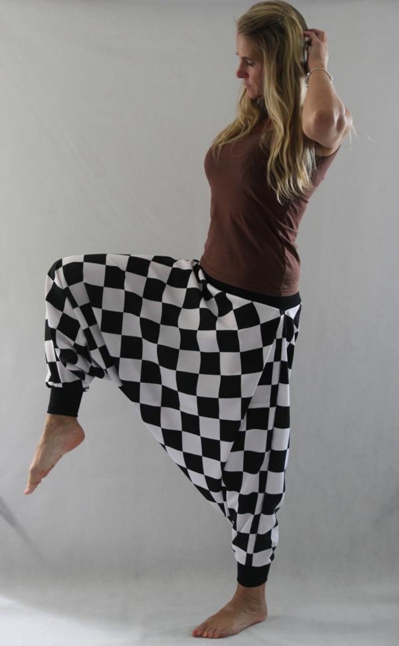 May include: A person wearing black and white checkered pants with a brown top.