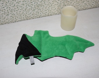 May include: A green and black plush bat with a felt texture. The bat is lying on a white surface.